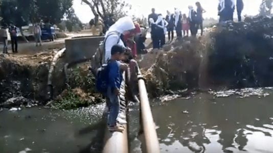 طلاب يعبرون ماسورة في البحيرة